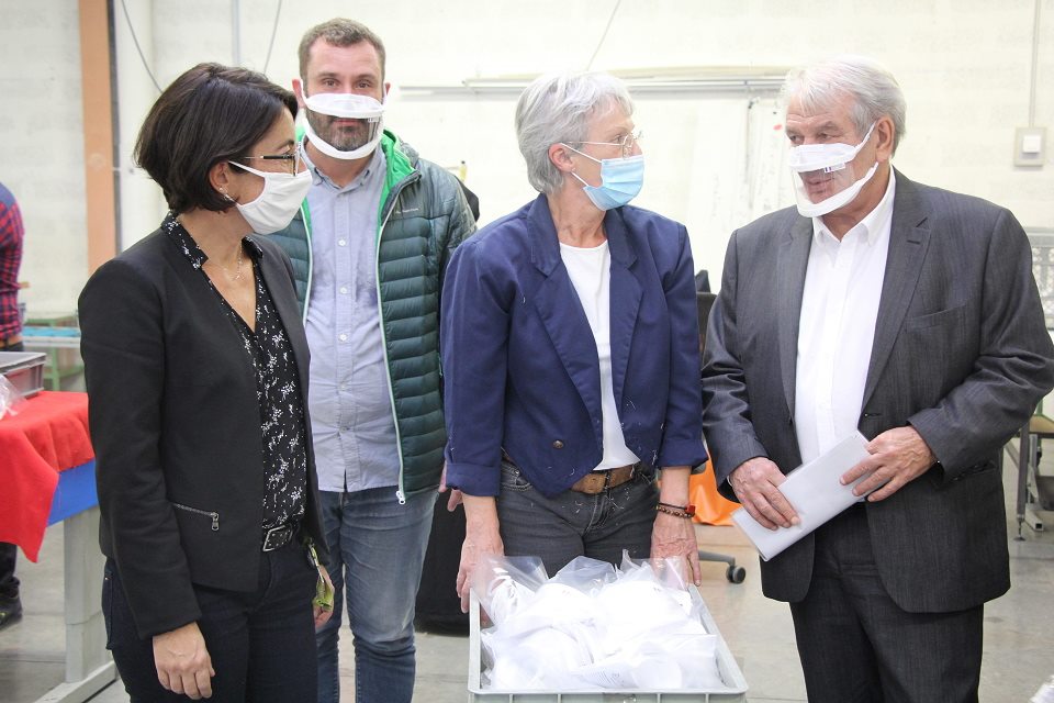 La première adjointe Amandine Demore et le maire Renzo Sulli entourent une salariée de l'ESAT devant un lot de masques inclusifs dont la Ville a fait l'acquisition.