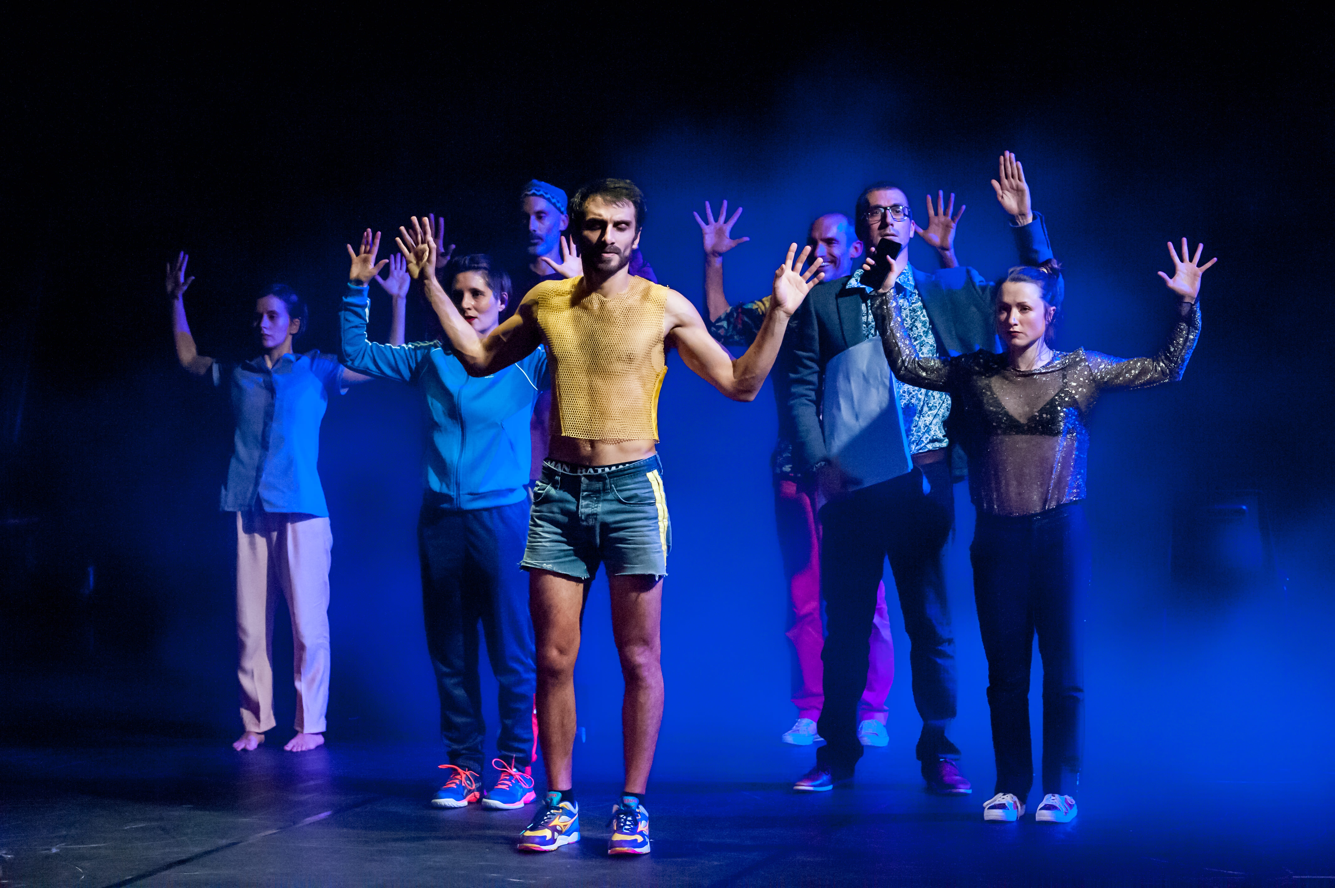 Spectacle "Dans le détail" La Rampe 2020 Les danseurs se tiennent debout les bras écartés au niveau de la tête, les paumes des mains faces aux spectateurs.