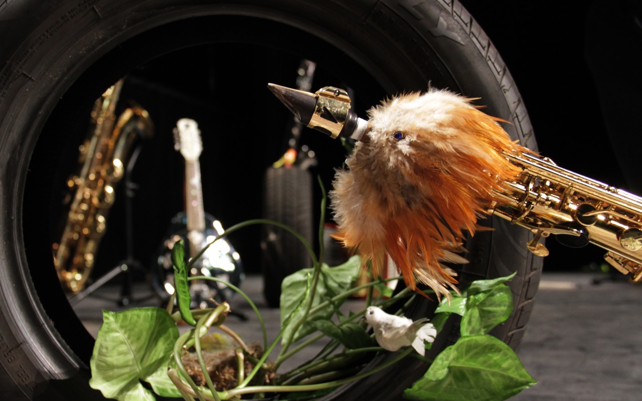Spectacle "L’Arbre Canapas" La Rampe 2020 Les instruments de musique sont posés sur la scène. L'un d'eux a une fausse tête d'oiseau accroché à son extrémité.