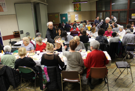 Des hommes servent le repas aux convives de la soirée-débat au centre social Anne-Frank.
