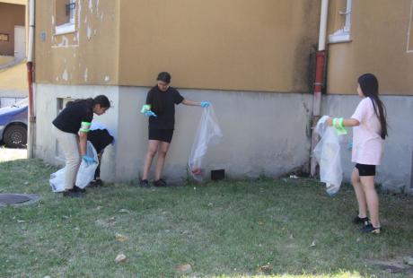  Photo prise dans le cadre de l'opération Ville propre.  Nous voyons des bénévoles, équipées de  gants, de pinces et de sacs, ramassant les déchets par terre.