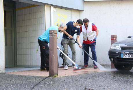 Photo prise dans le cadre de l'opération Ville propre.  Nous voyons des habitants en train de nettoyer les entrées des immeubles.