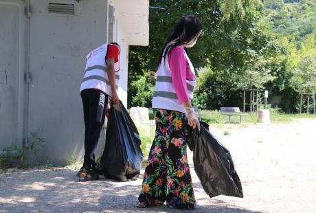 Photo prise dans le cadre de l'opération Ville propre.  Nous voyons des bénévoles, équipées de  gants, de pinces et de sacs, ramassant les déchets par terre.