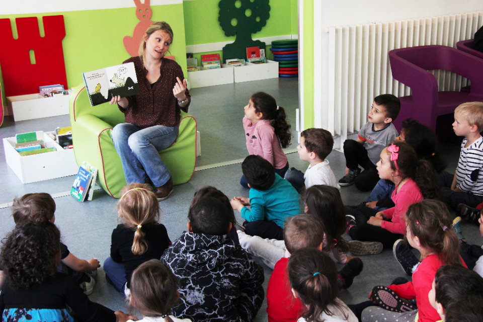 Une bibliothécaire présente l'auteur Sylvain Diez à des enfants de l'école maternelle Joliot-Curie