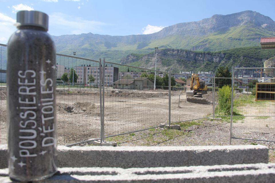 Pose de la première pierre du Centre de sciences. Photo du terrain où se déroulent les travaux. Nous voyons des barrières, des machines de chantier.