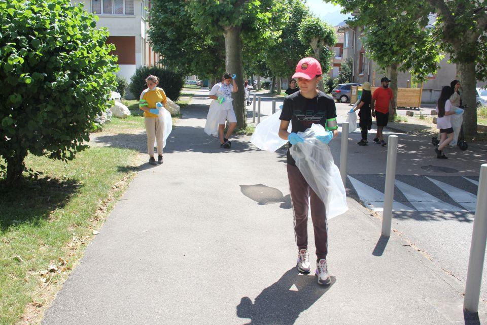  Photo prise dans le cadre de l'opération Ville propre.  Nous voyons des bénévoles, équipées de  gants, de pinces et de sacs, ramassant les déchets par terre.