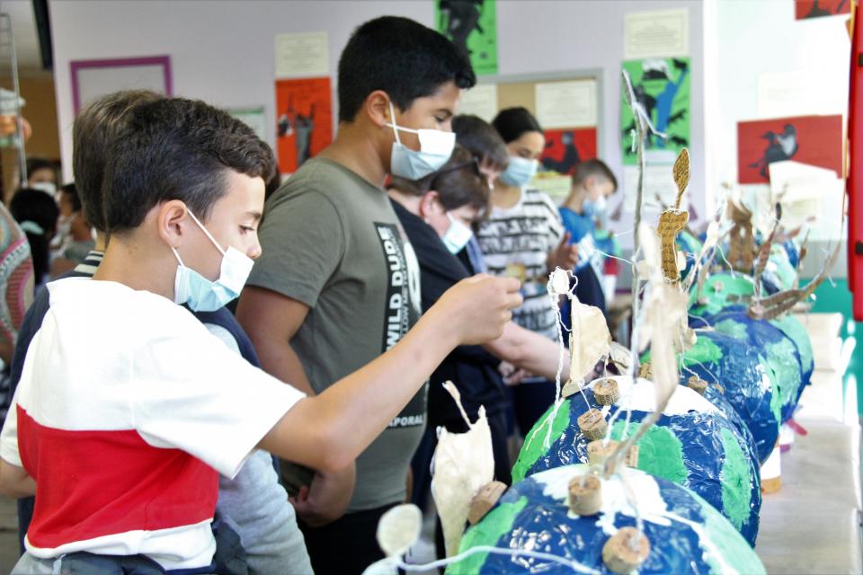 Photo prise dans le cadre du projet Projet philo-plastique. Nous voyons des jeunes en train de construire des maquettes avec du plastique, en lien avec des réflexions environnementales.