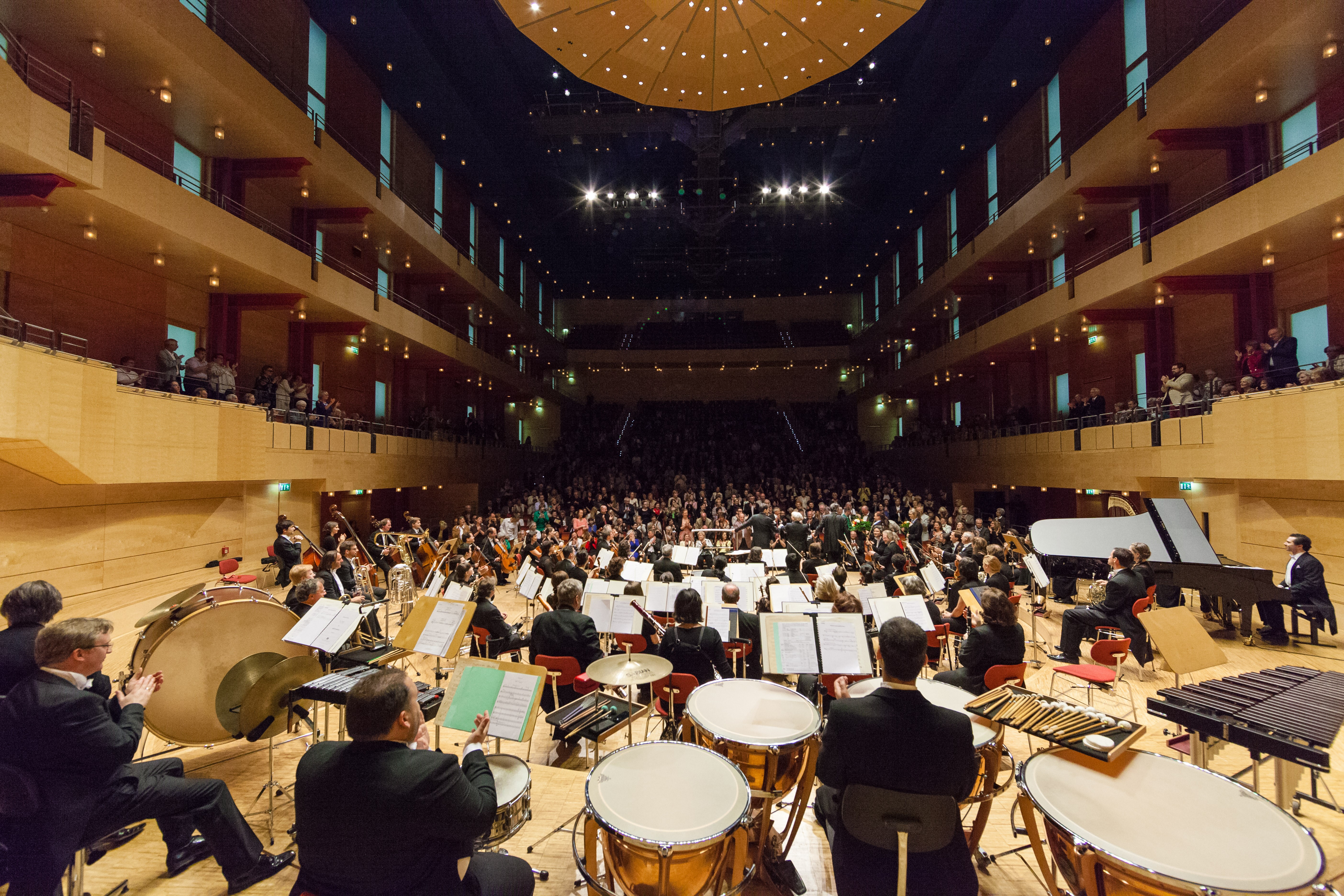 Vue du Philharmonie de Baden-Baden en plein concert. La photo est prise à l'arrière du philharmonie. Les musiciens sont de dos et le public nous fait face.