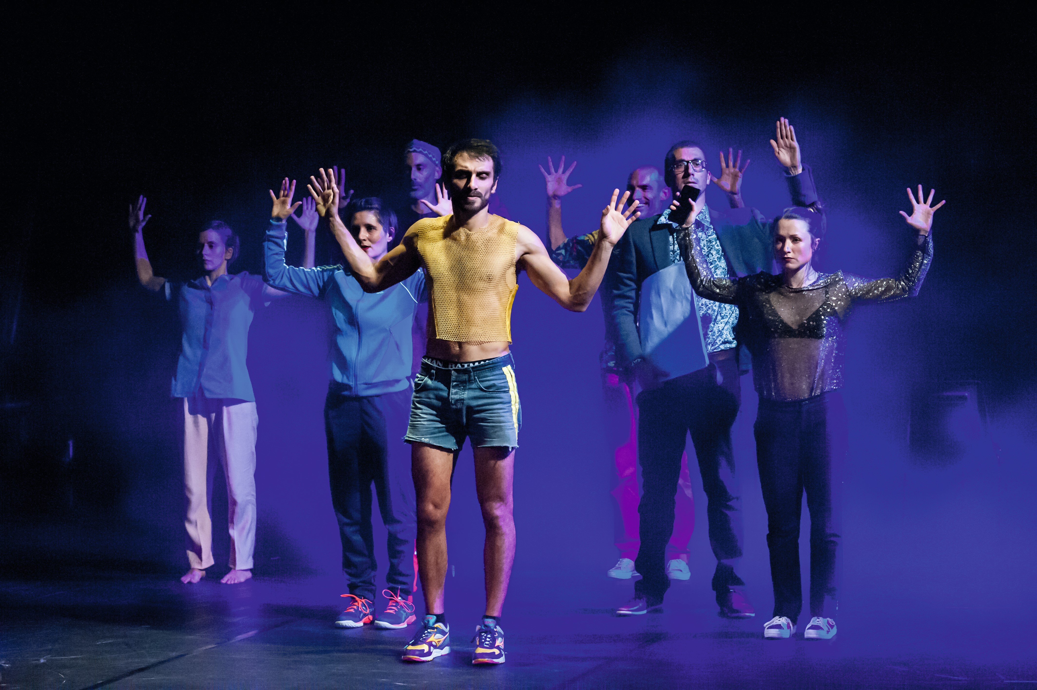 Les danseurs se tiennent debout les bras écartés au niveau de la tête, les paumes des mains faces aux spectateurs.