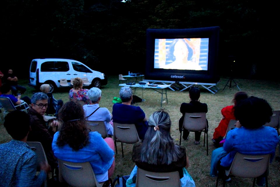 Le public assiste à la projection du film Nouvelle cordée à la tombée de la nuit dans les parcs de la ville.