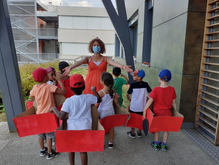 Les enfants et leur encadrante présentent les chars qu'ils ont réalisé.