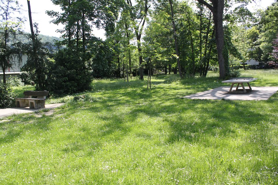 Parc Elie-Blanchet vue du Parc Elie-Blanchet. Un banc est sur la gauche. Une table de ping-pong en pierre est sur la droite.