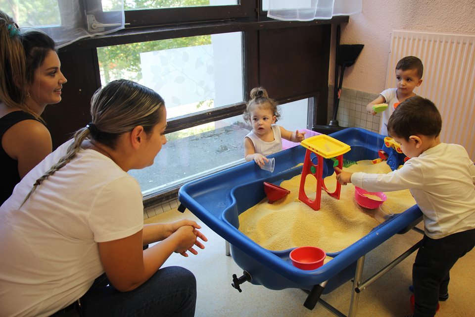 Des enfants jouent accompagnés de leurs parents