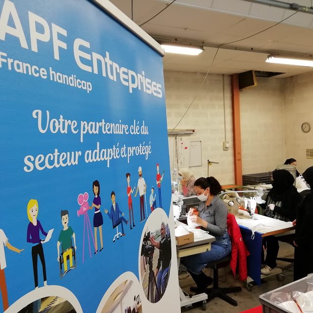 Dans l'atelier, une affiche présente les différents métiers de l'APF Entreprises.