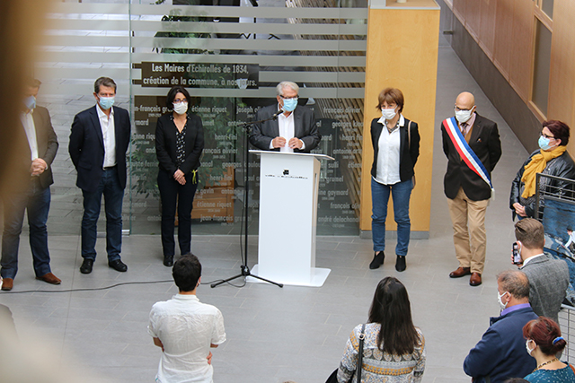 Vue depuis une passerelle surplombant l'atrium de l'Hôtel de Ville. Le maire, entouré de ses adjoints, rend hommage à Samuel Paty à travers un discours.