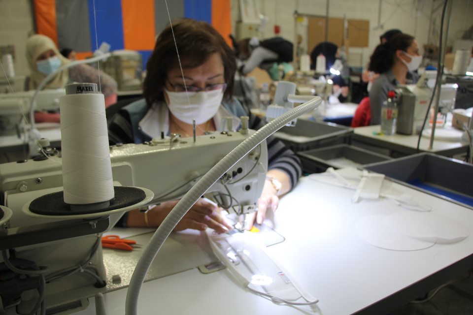 Une couturière s'affaire sur sa machine pour confectionner l'un des élèments des masques inclusifs.