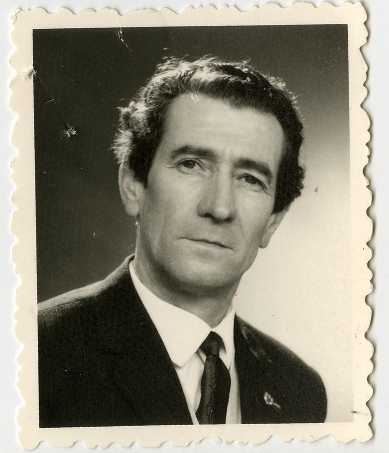 Photo d'identité de Pierre Moussy Photo d'identité de Pierre Moussy, en 1973, après la guerre. Il porte un costume, une chemise et une cravate. La photo est en noir et blanc.