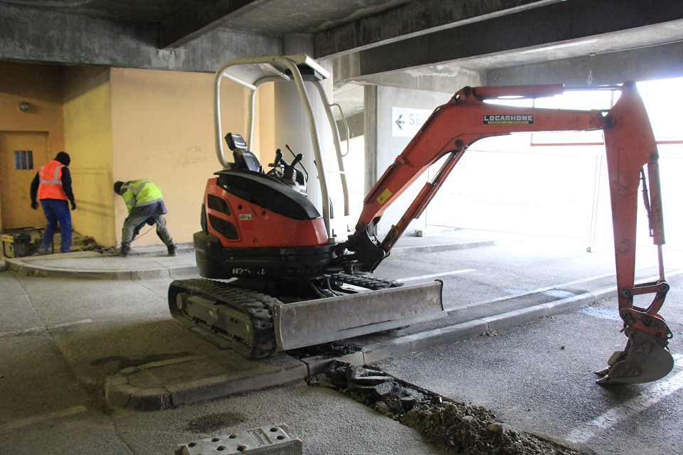 Les travaux de sécurisation du parking, qui devraient s'achever mi-janvier, ont permis d'embaucher deux jeunes du quartier orientés par le service prévention de la Ville. Sur la photo nous voyons des personnes travailler et des outils de chantier.