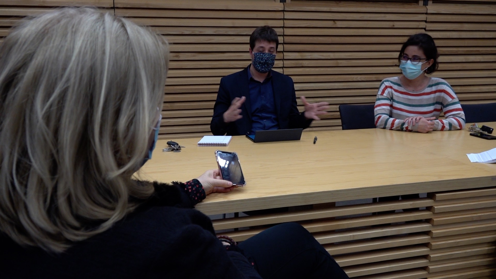 Aurélien Farge et Amandine Demore, respectivement conseiller municipal et première adjointe en charges du développement numérique, présentent la démarche d'élaboration de la stratégie numérique de la Ville pour les années à venir. Ils sont tous les deux assis derrière un bureau, face à eux se tient une journaliste.