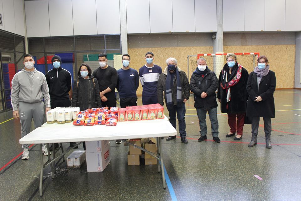 Distribution alimentaire Human Help Les jeunes bénévoles de l'association Human Helop posent, tous masqués, avec le maire Renzo Sulli, la première adjointe Amandine Demore, les adjoint-es Sylvette Rochas et Yacine Hamidi, et la conseillère municipale Sandrine Yahiel. Devant eux il y a une table avec des produits alimentaires qui vont être distribués.