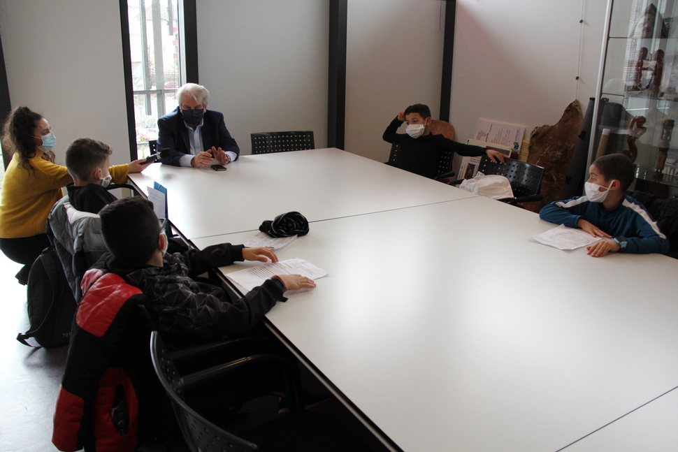 Tous masqués et assis autour d'une table, les collégiens questionnent et interrogent le maire Renzo Sulli.
