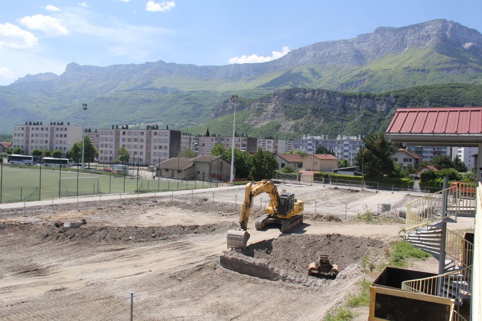 Chantier construction du Centre de sciences Pose de la première pierre du Centre de sciences. Photo du terrain où se déroulent les travaux. Nous voyons des barrières, des machines de chantier.