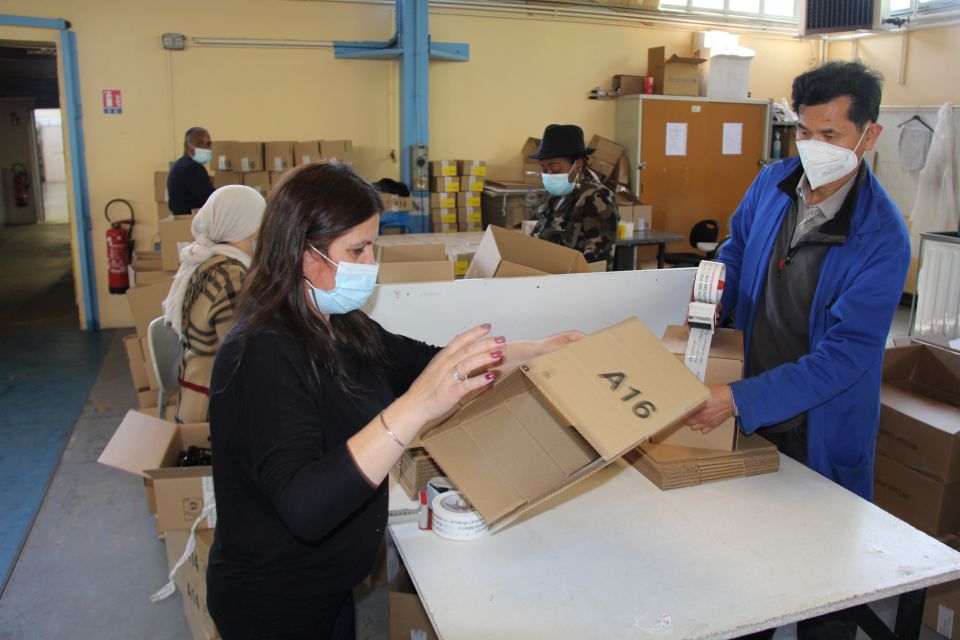 Photo d'un atelier. Nous voyons des personnes en train d'emballer des produits.