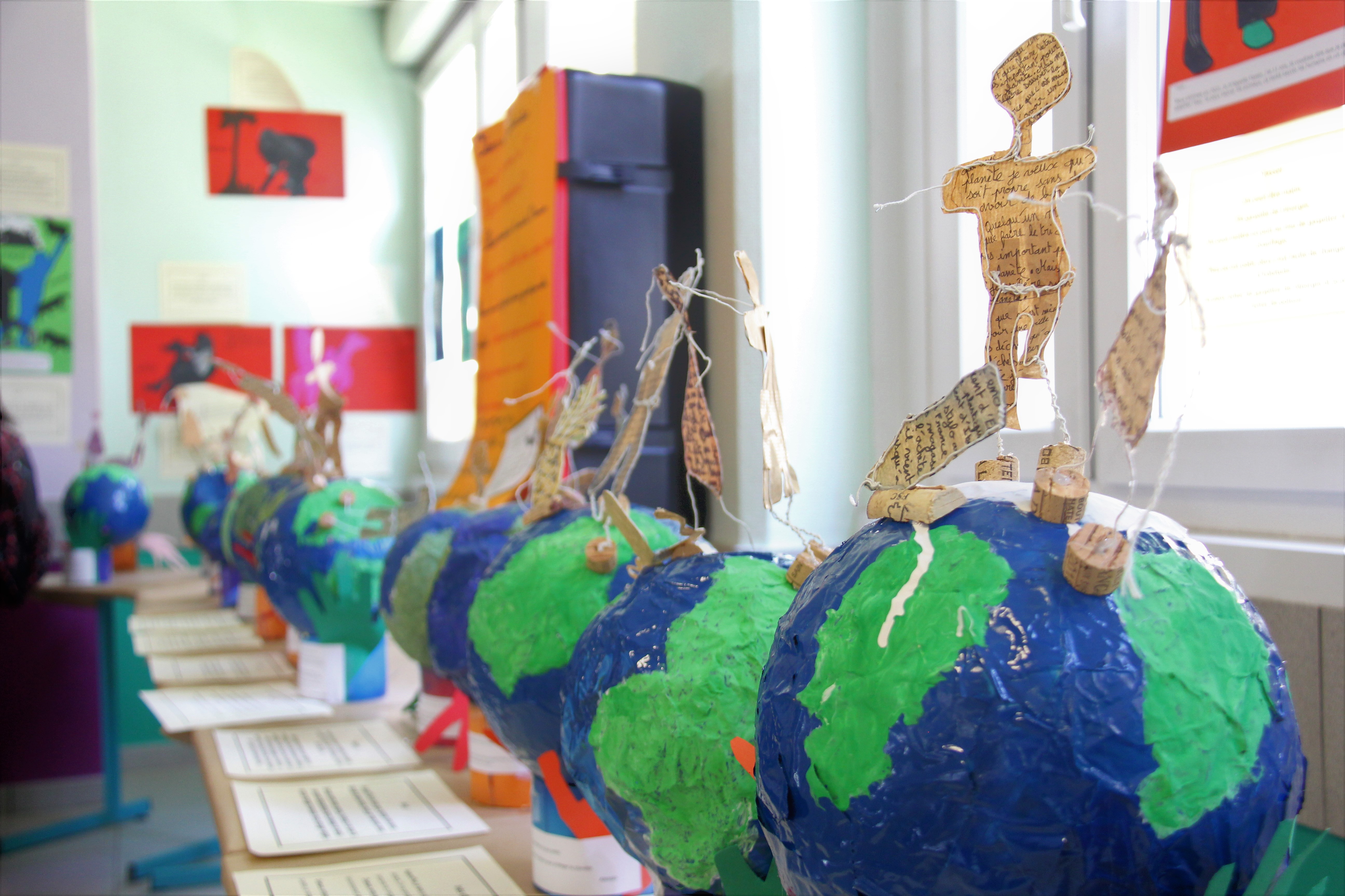 Projet Philo-plastique : Le débat prend forme Photo prise dans le cadre du Projet Philo-plastique. Nous voyons des maquettes de la terre réalisées avec du plastique pour sensibiliser aux enjeux écologiques.