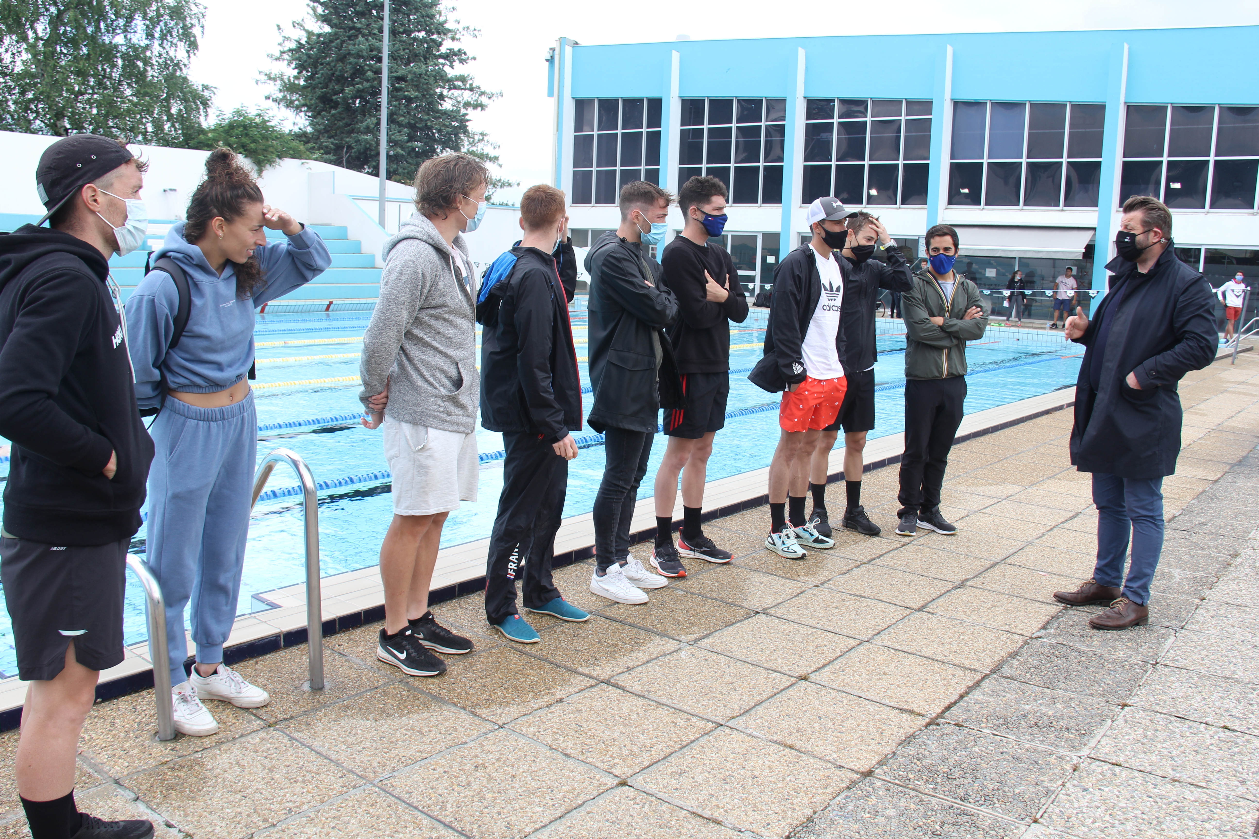 Pierre Labriet, adjoint au sport de la Ville, échange avec Dorian Coninx et l'ensemble de son groupe d'entraînement, au Stade nautique.  