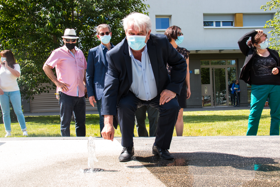 le maire, Renzo Sulli, devant la fontaine de Village 2. Photo prise dans le cadre de la remise en eau des fontaines 2021; Nous voyons le maire, Renzo Sulli, devant la fontaine de Village 2. Derrière lui se tiennent certains élus