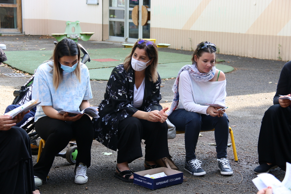 Sur le banc avec un parent, Nadia Majdi au centre et Laurène Berthollet à droite Photo de parents assis sur un banc dans la cour d'une école