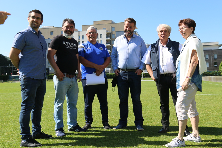 Photo prise à l'occasion de la remise des premiers Chèques sport avec les élus de la Ville, OSE et le FCE. Nous voyons le maire et les élu-es qui posent sur le terrain de foot avec les jeunes joueurs et les encadrants du club de foot.