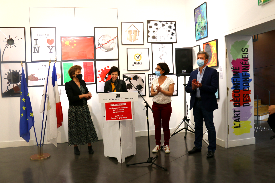 Photo de l'exposition "L’art déconfiné des confinés" au centre du graphisme. Photo du discours de Virginie Vignon, conservatrice du musée. A ses côtés se tiennent  Jacqueline Madrennes, adjointe à la Culture,  Amandine Demore, première adjointe, et Daniel Bessiron, adjoint à l'Environnement durable présents pour l'inauguration de l'exposition.