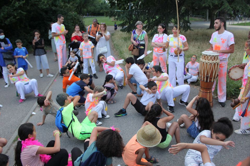 Photo prise à l'occasion de l'événement Carna’light. Les participants sont habillés de vêtements blanc avec des marques fluorescentes dessus. On voit des enfants s'initier au hip hop