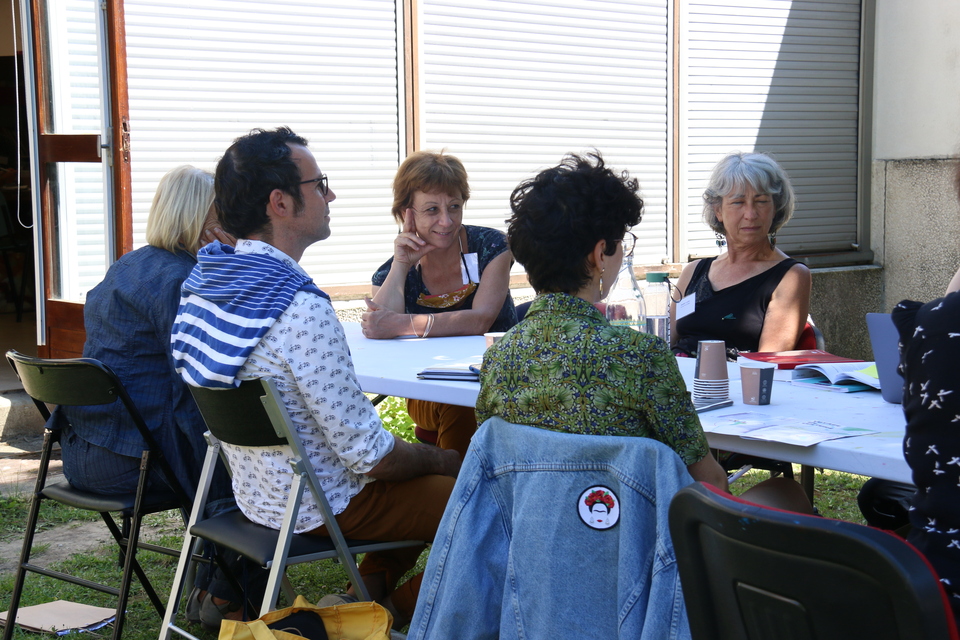 Photo prise lors du Parlement culturel.  Une dizaine de personne sont assis autour d'une table et échangent autour des enjeux culturels sur le territoire.