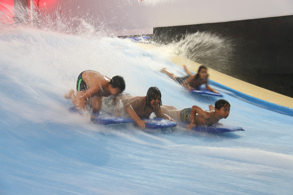 Atout sport surfe sur la vague Photo de jeunes surfant sur des vagues artificielles, au complexe La Vague