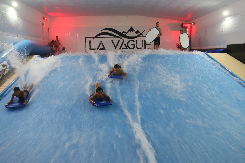 Au complexe La Vague Photo de jeunes surfant sur des vagues artificielles, au complexe La Vague