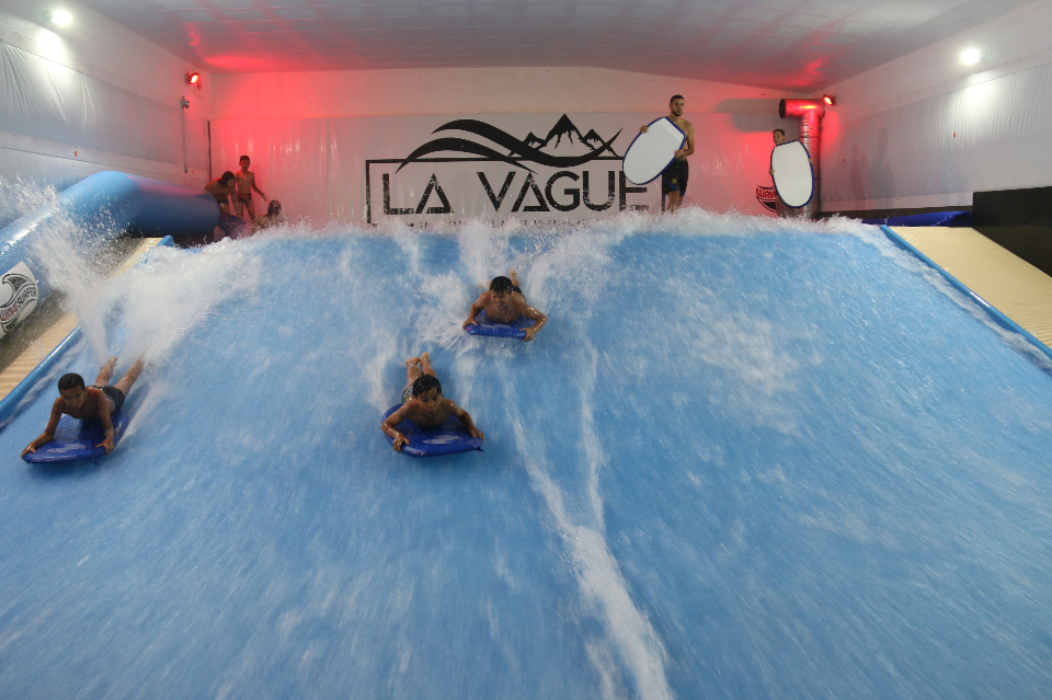 Photo de jeunes surfant sur des vagues artificielles, au complexe La Vague