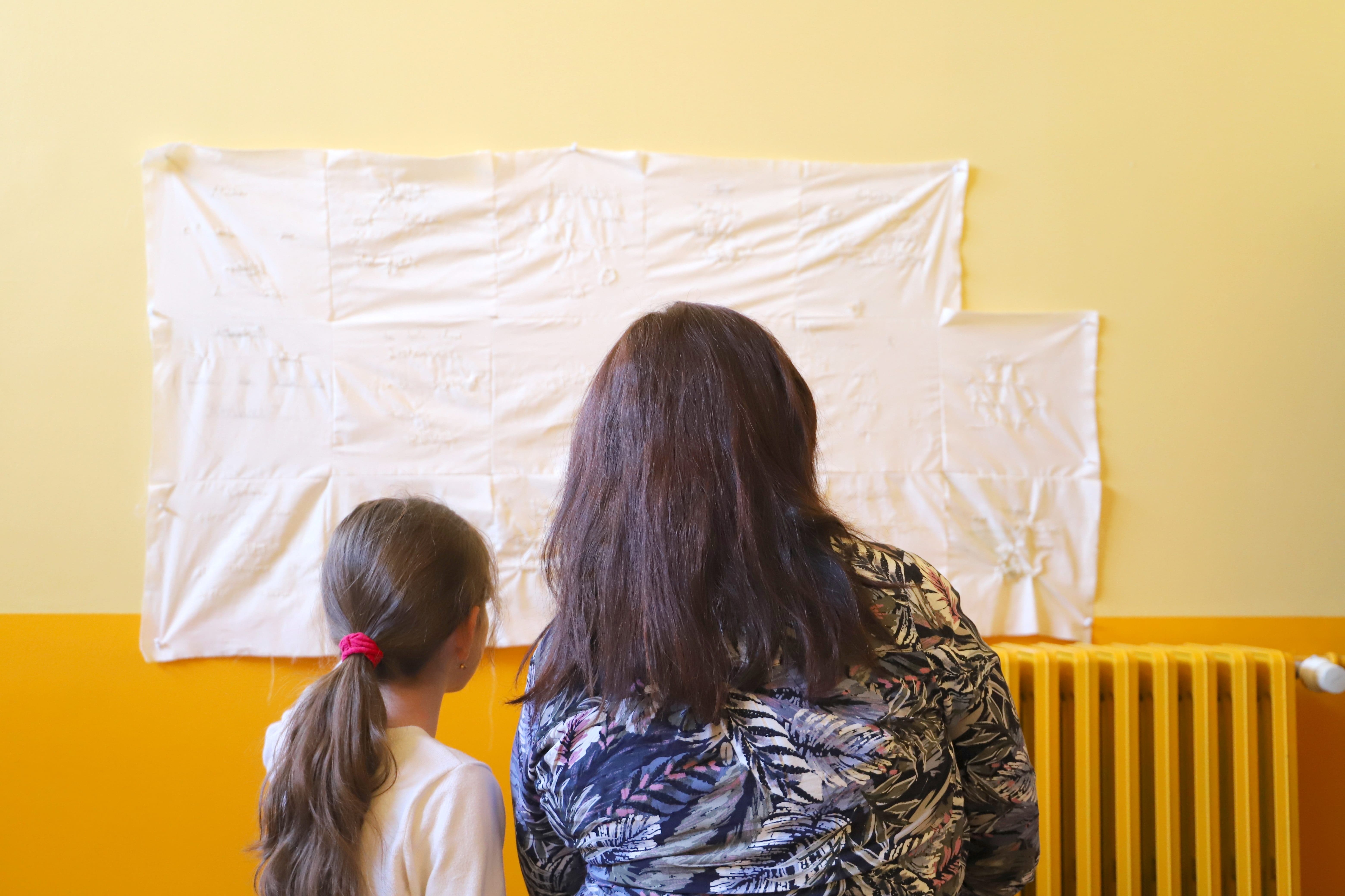 Une maman et sa fille devant des productions de l'atelier