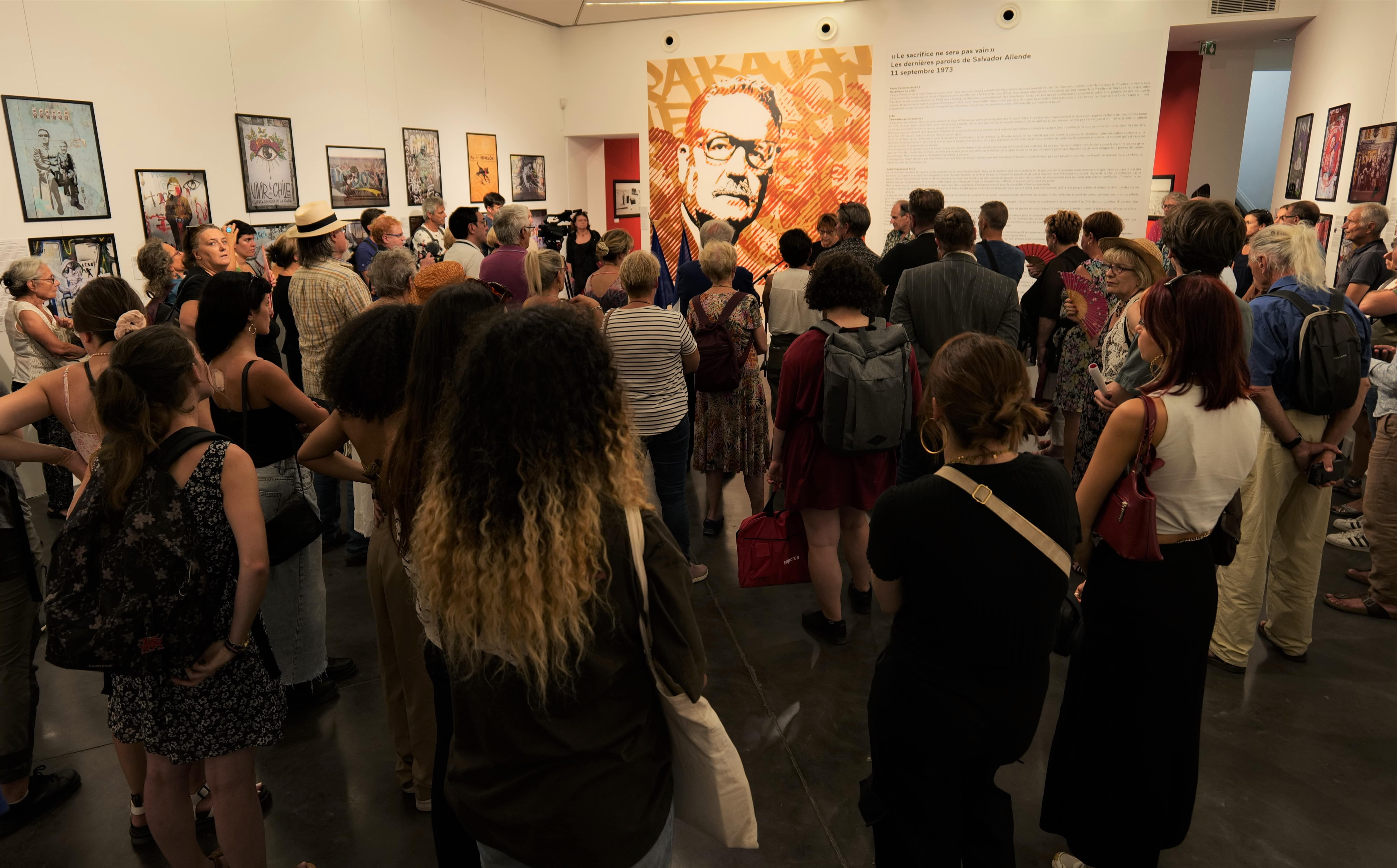Lors du vernissage de l'exposition, les visiteurs découvrent les photos d'une explosion graphique sur les murs de Santiago en 2019.