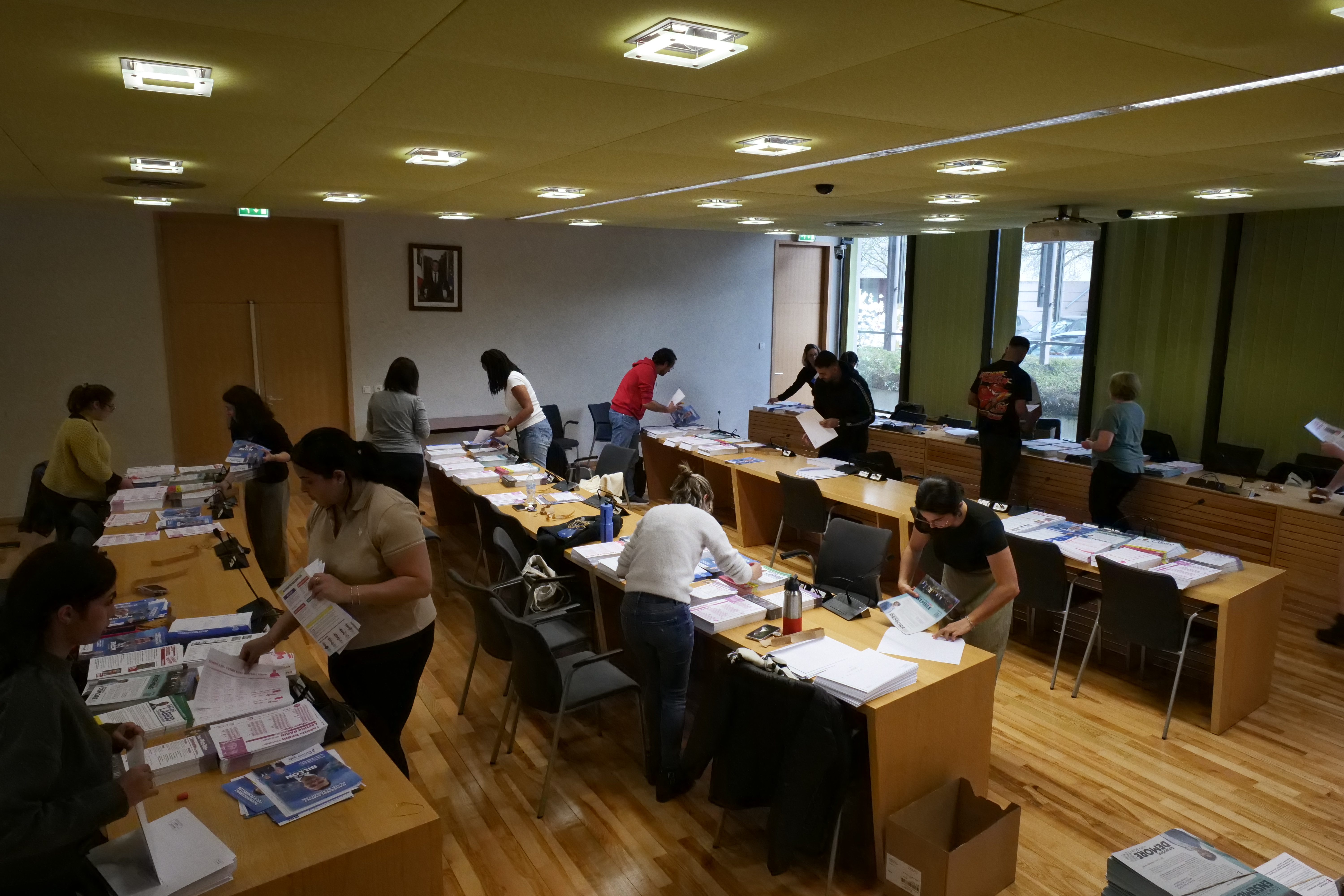 Personnes mettant sous pli les professions de foi dans la salle du conseil