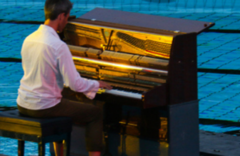 homme qui joue au piano sur une piscine