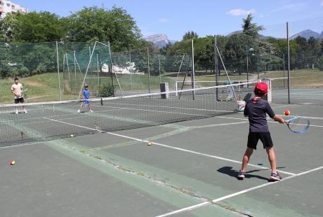 Des jeunes jouent au tennis.