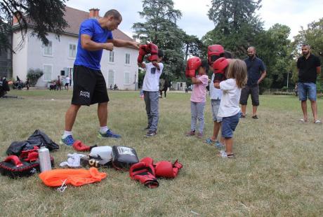 Initiation boxe pour les plus petits. Le formateur leur apprend à lever les poings devant le visage.