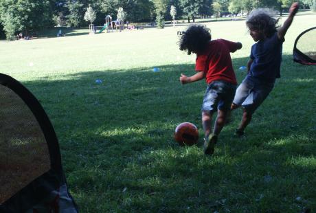 Match de foot en cours. Deux joueurs sont dans un face à face pour avoir le ballon.