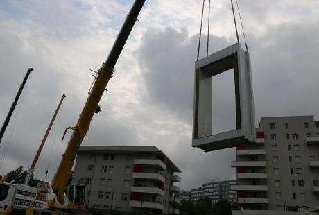 Une grue soulève l'encadrement de porte d'un module.