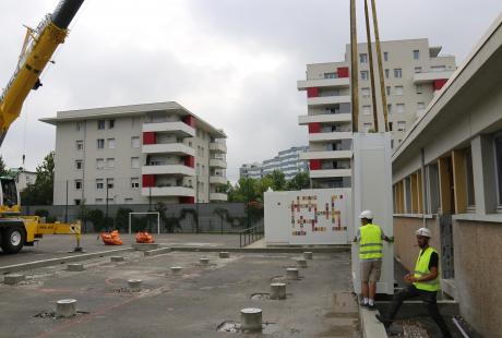 Soulevé par la grue, l'encadrement de porte est positionné par les agents techniques.