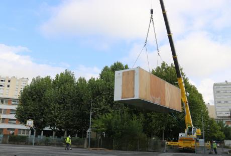 Les modules sont soulevés et déplacés par les grues.