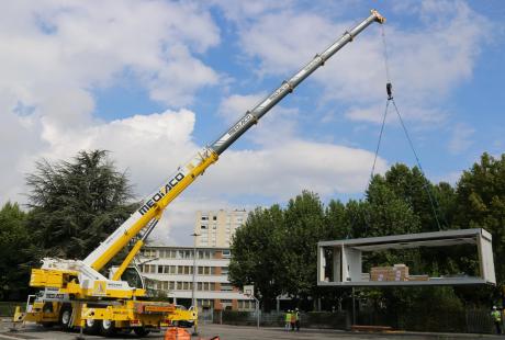 Les modules sont soulevés et déplacés par les grues.