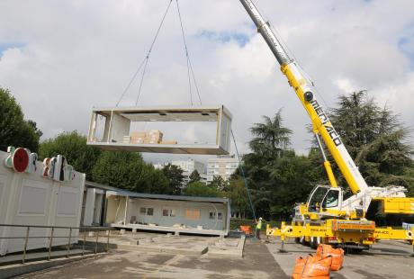 Les modules sont soulevés et déplacés par les grues.